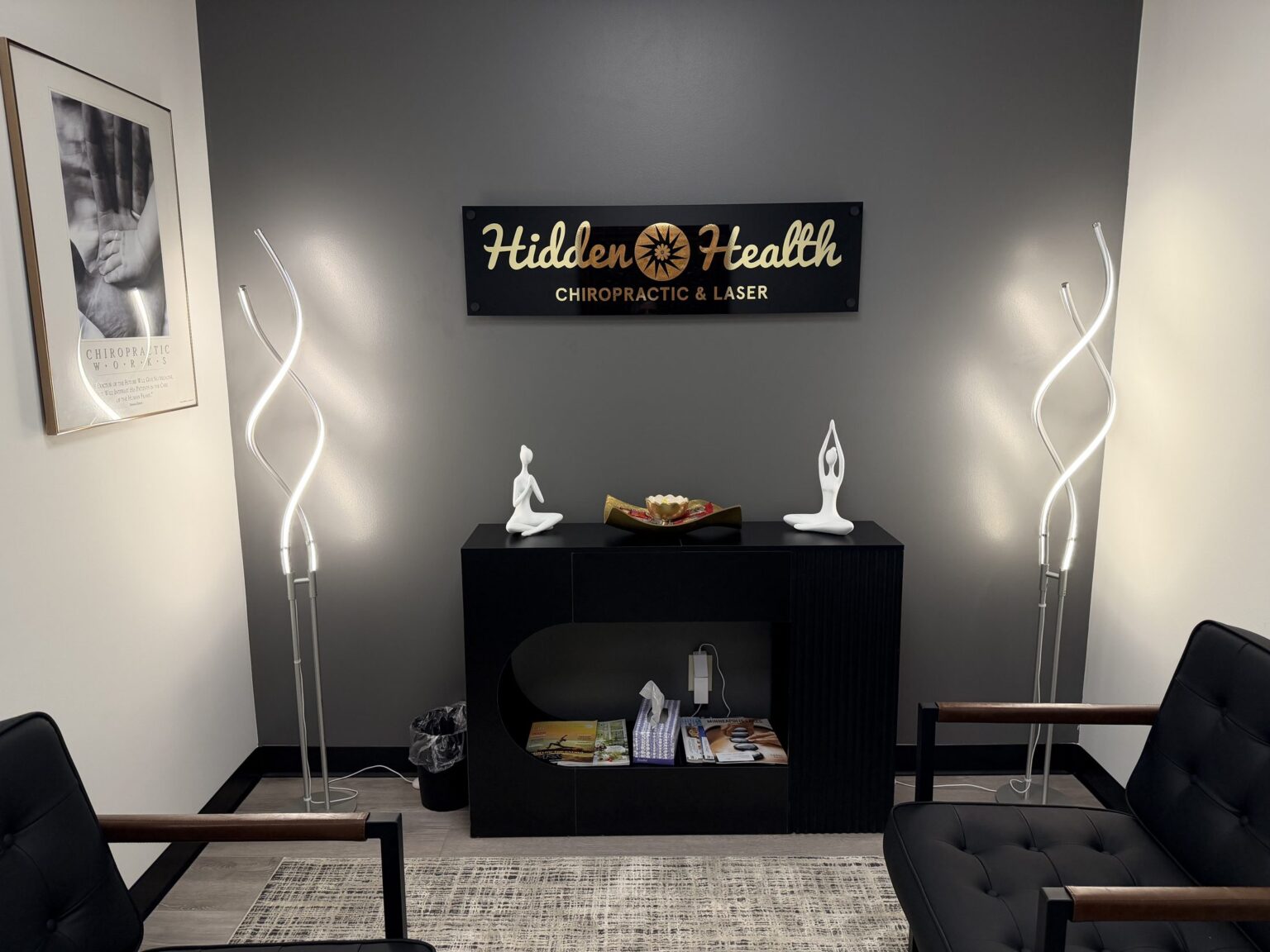 The Hidden Health reception area in Edina, with the gold sunburst logo sign, soft lamps and leather chairs